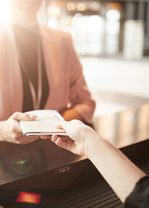 Close-up of businesswoman standing near the reception and taking brochure for business conference