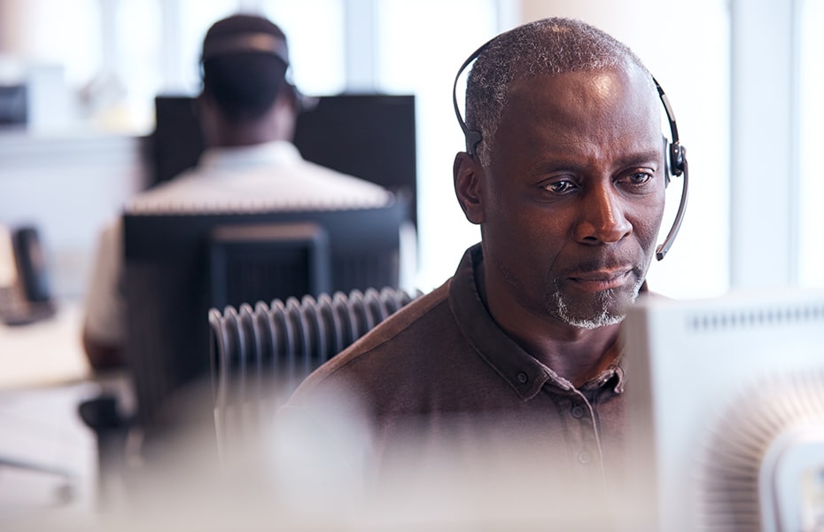 Men working as virtual receptionist on a computer