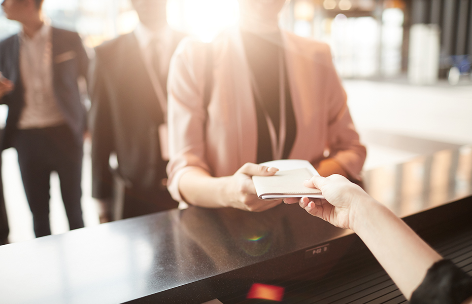 Close-up of businesswoman standing near the reception and taking brochure for business conference